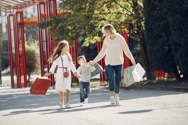 Madre con niño con bolsa de compras en una ciudad