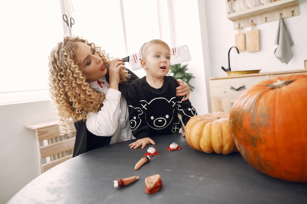 Madre con niño en disfraces y maquillaje. La familia se prepara para la celebración de Halloween.