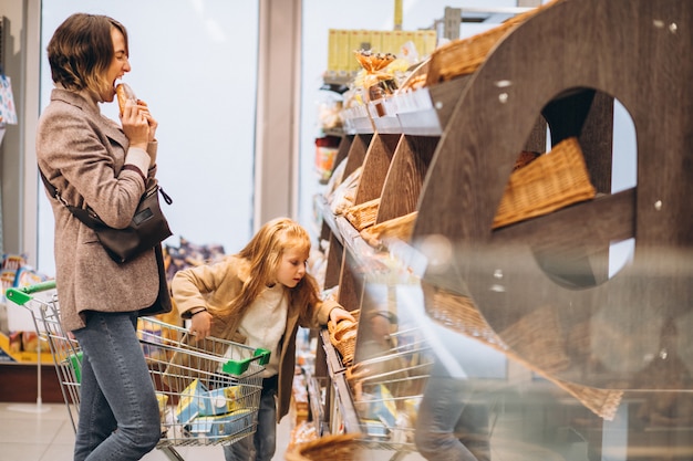 Madre con niño elegir pan en una tienda de comestibles