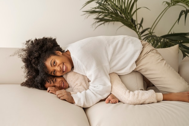 Madre y niño sonrientes de tiro completo en casa