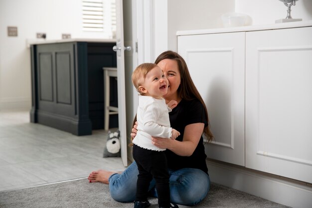 Madre y niño sonrientes de tiro completo en el interior