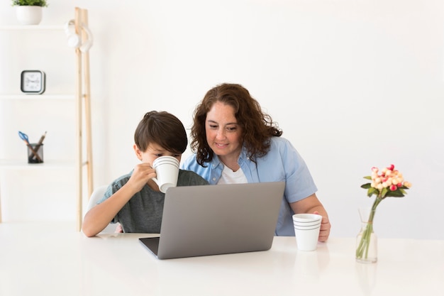 Foto gratuita madre con niño trabajando en la computadora portátil