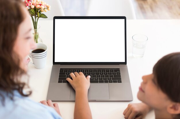 Madre con niño trabajando en la computadora portátil