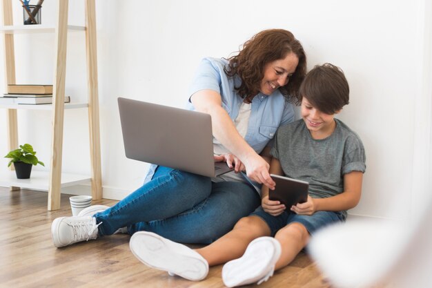 Madre con niño trabajando en la computadora portátil