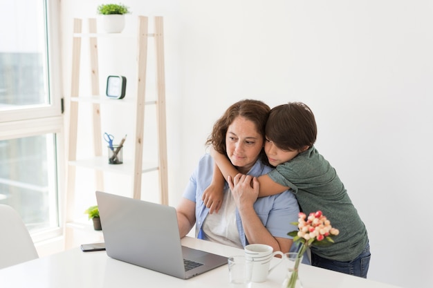 Foto gratuita madre con niño trabajando en la computadora portátil