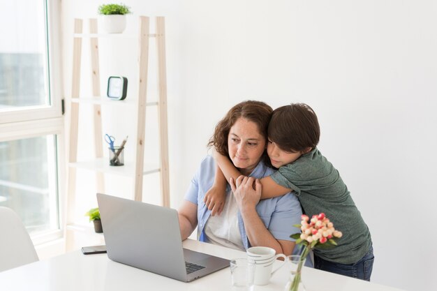 Madre con niño trabajando en la computadora portátil