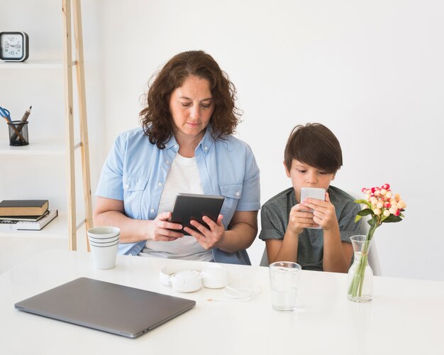 Madre con niño trabajando en tableta