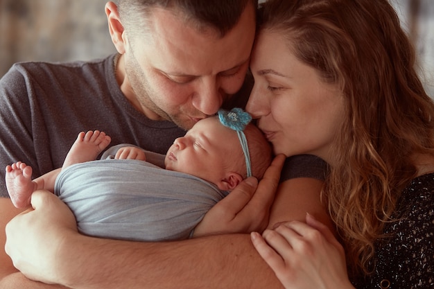 Foto gratuita la madre y el padre abrazan a su hija