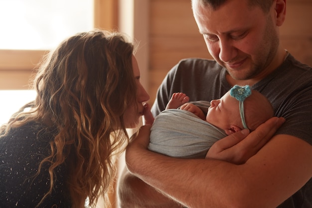 La madre y el padre abrazan a su hija