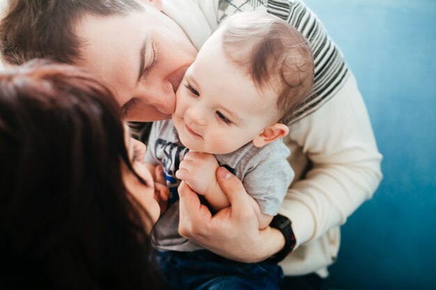 La madre y el padre abrazan a su hijo