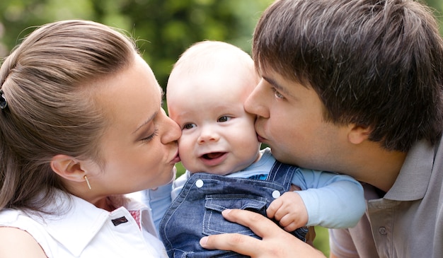 Madre y padre besando a su pequeño niño