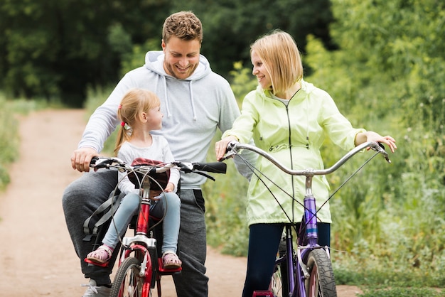 Madre y padre ciclismo con hija