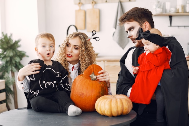 Madre padre e hijos en disfraces y maquillaje. La familia se prepara para la celebración de Halloween.