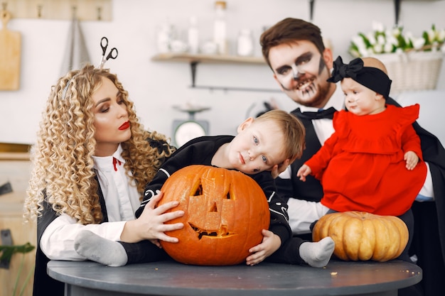 Madre padre e hijos en disfraces y maquillaje. La familia se prepara para la celebración de Halloween.