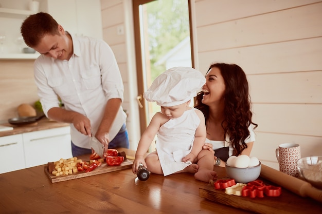 La madre, el padre y el hijo sentados en la cocina