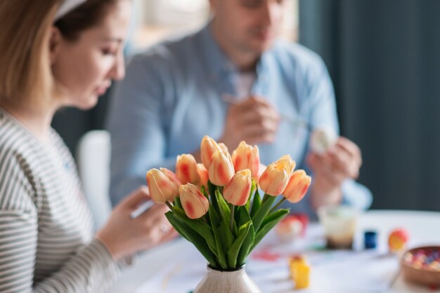 Madre y padre pintando huevos para pascua