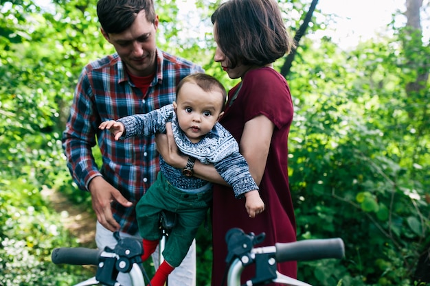 Madre, padre, poniendo, niño, bicicleta