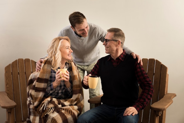 Foto gratuita madre y padre posando con hijo mientras sostiene tazas