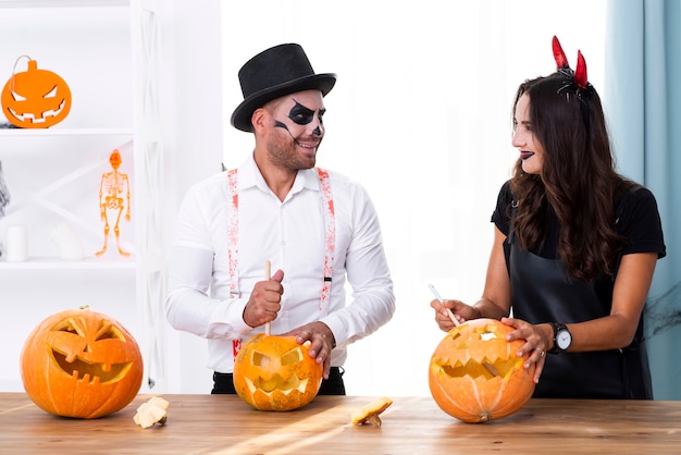 Madre y padre tallando calabazas