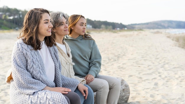 Foto gratuita madre pasar tiempo en la playa con sus dos hijas.