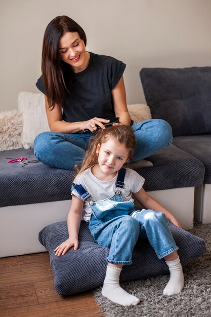 Madre peinando a sus hijas lindas