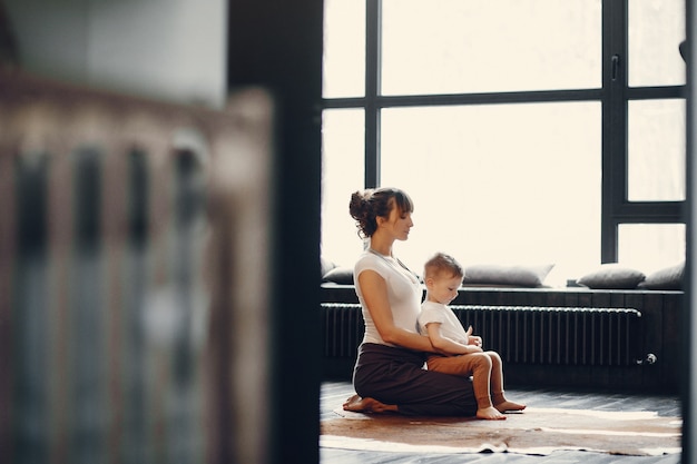 Madre con pequeño hijo haciendo yoga en casa