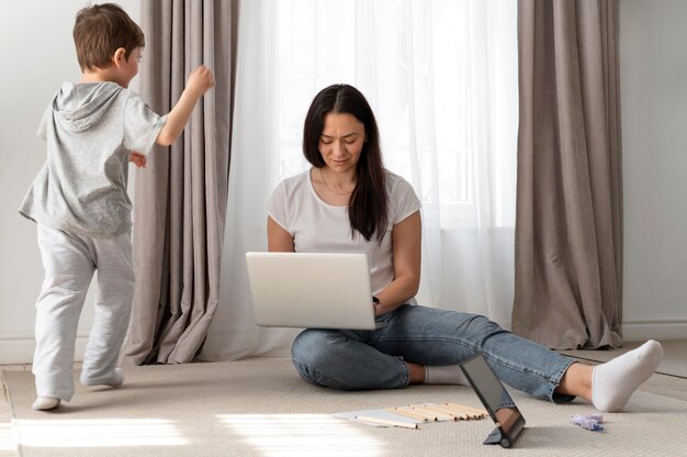 Madre de plano completo trabajando de forma remota