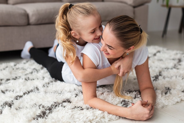 Foto gratuita madre posando con hija en casa