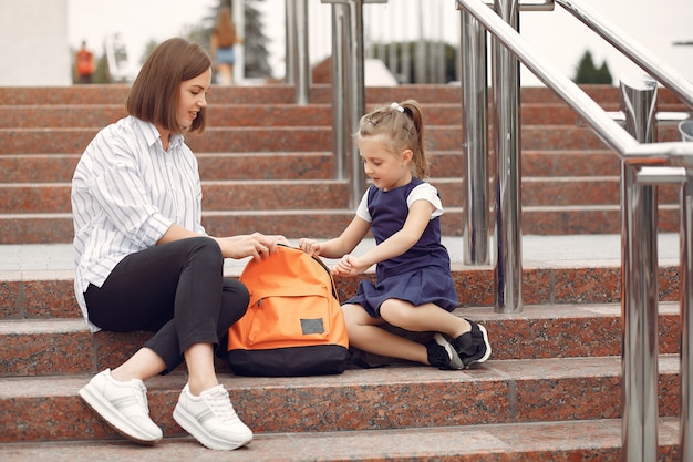 Madre prepara pequeña hija a la escuela