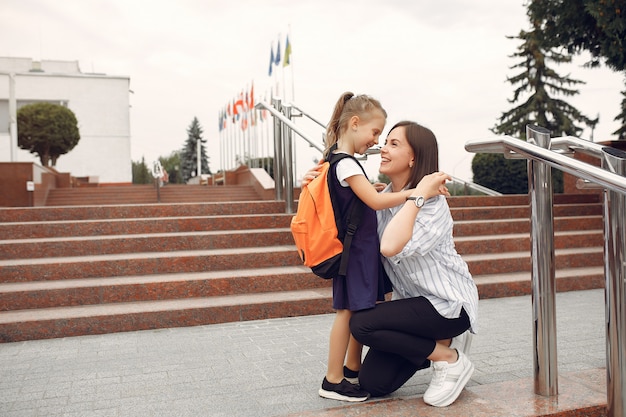 Madre prepara pequeña hija a la escuela