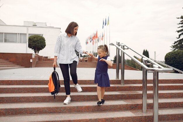 Madre prepara pequeña hija a la escuela