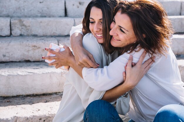 madre con regalo abrazando a mujer