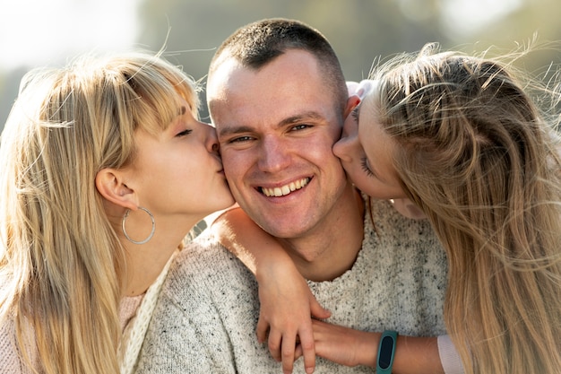 Madre rubia y encantadora hija besando a su padre