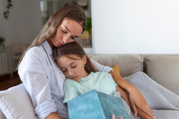 Madre soltera se siente dormida mientras lee un libro a su hija