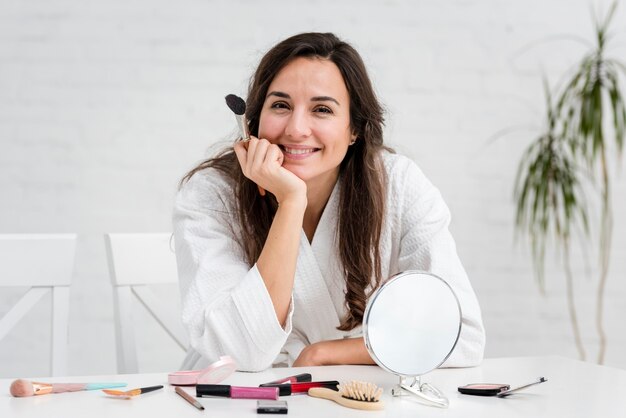 Madre sonriente haciendo su maquillaje