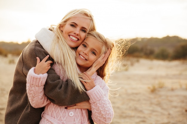 Madre sonriente jugando con su pequeña hija