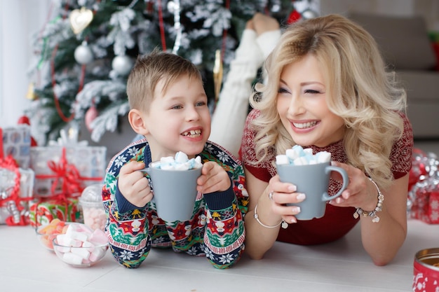 madre sonriente y niño en casa con ropa acogedora