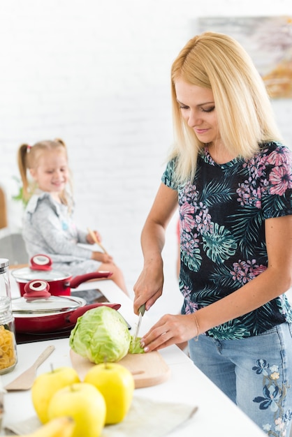 Madre sonriente preparando comida en la cocina