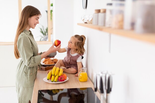 Madre sonriente que alimenta a la hija