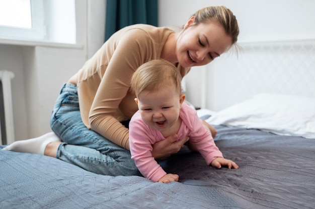 Madre sonriente de tiro completo con bebé