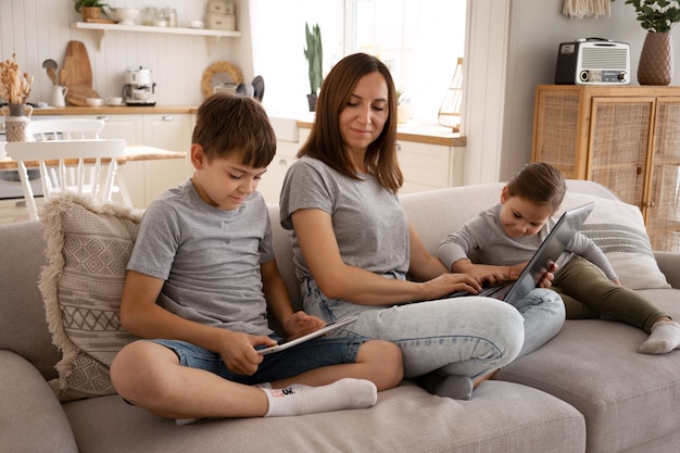 Foto gratuita madre sonriente de tiro completo con niños