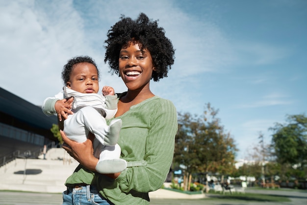 Foto gratuita madre sonriente de tiro medio con bebé