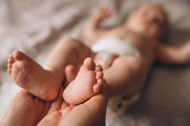 Madre sosteniendo los pies del bebé recién nacido