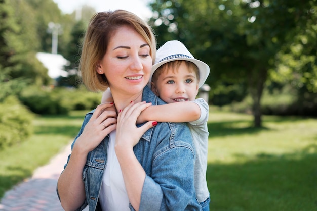 Madre sosteniendo a su hijo plano medio