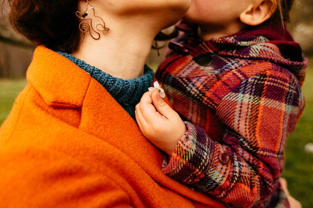 Foto gratuita la madre sostiene en las manos a su hija en el parque