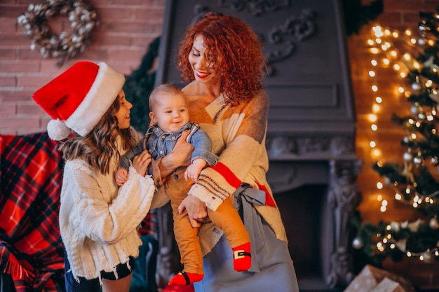 Madre con su hija e hijo en navidad por arbol de navidad