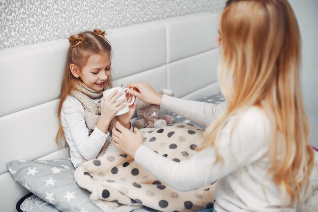 Madre con su hija illnes en un dormitorio