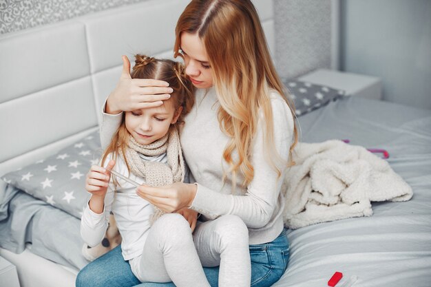 Madre con su hija illnes en un dormitorio