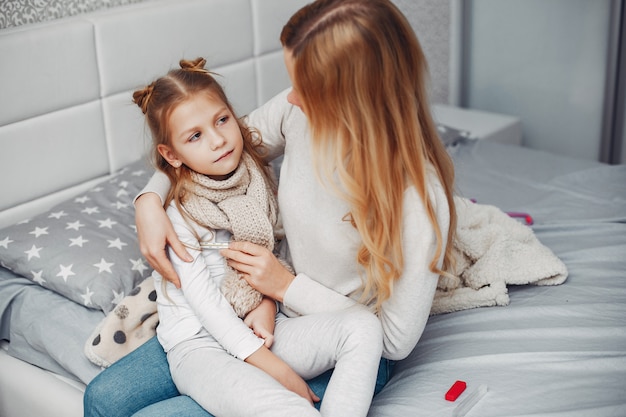 Madre con su hija illnes en un dormitorio