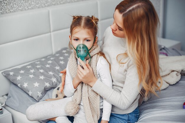 Madre con su hija illnes en un dormitorio